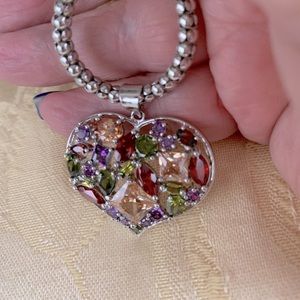 Silver heart on 17-18” chain with multicolored stones.  Excellent condition